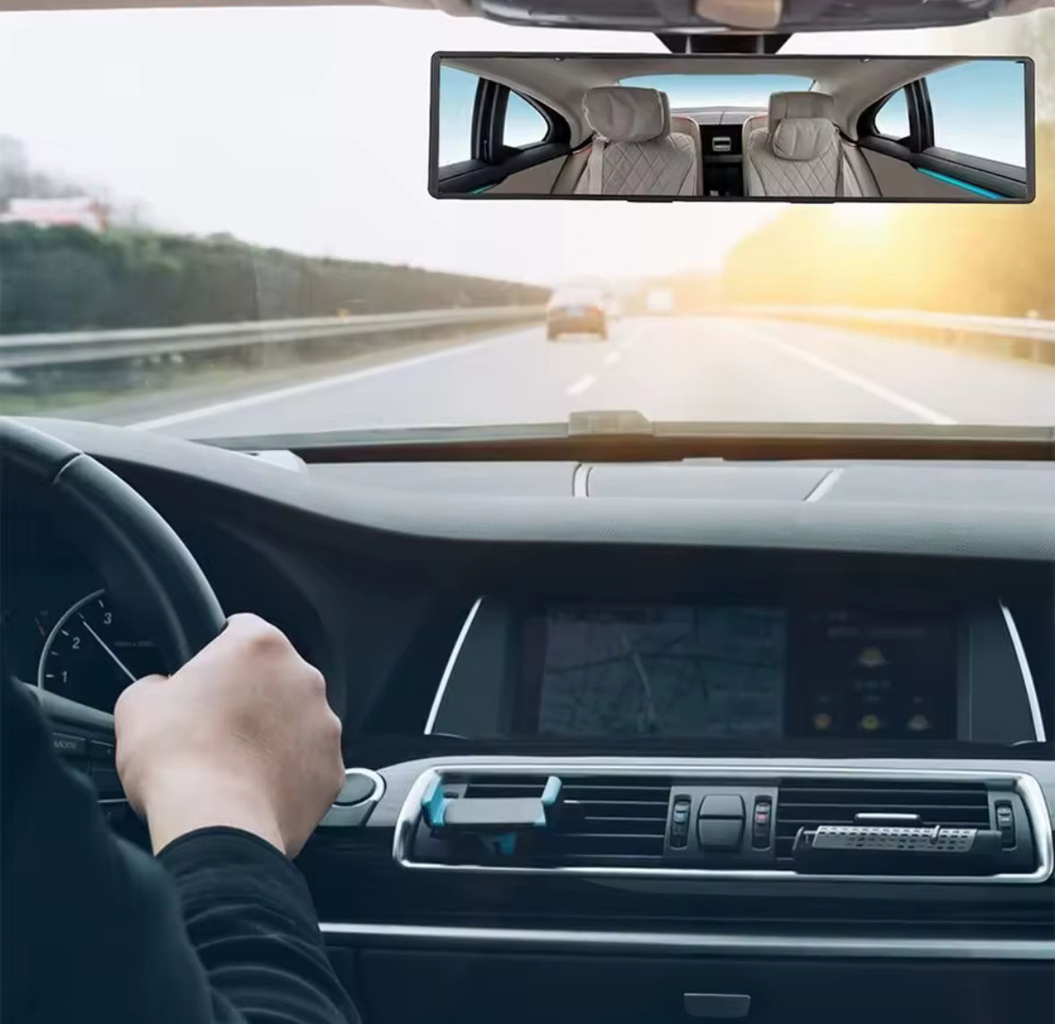 Person driving a car on a highway with a clear view of the road ahead.